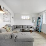 A living room with gray sofa, glass table, and blue shelf.