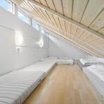 Dachgeschosszimmer mit Matratzen und Holzdecke