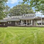 Moderne Villa mit Terrasse, Grill und Garten. Umgeben von Bäumen und Grünflächen.