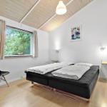 Schlafzimmer mit Bett, Fenster und Stuhl.