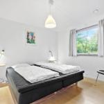 Schlafzimmer mit Doppelbett, Fenster und Stuhl.