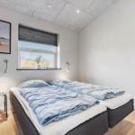 Schlafzimmer mit Doppelbett, Fenster und Wandbild.