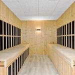 Sauna mit Holzwänden und Sitzbänken entlang der Wände.