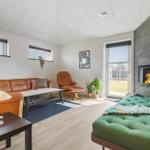 Wohnzimmer mit Sofa, Sessel, Kamin und grüner Schlafcouch.