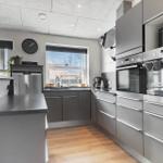 Moderne Küche mit Edelstahlgeräten und Holzboden.
