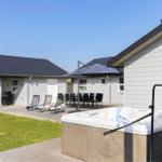 Außenbereich mit Whirlpool, Liegestühlen und Grillplatz.