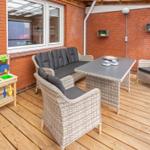 Terrasse mit Sitzgruppe, Kinderspielzeug und Holzboden.