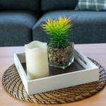 Auf dem Tisch steht ein weißer Kasten mit einer Pflanze und einer Kerze.