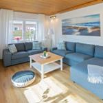 Wohnzimmer mit blauem Sofa, Holztisch und Fensterblick
