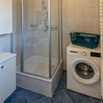 Bad mit Dusche, Waschmaschine und Handtuchständer