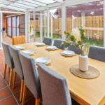 Essbereich mit Tisch und Stühlen, Terrasse und Gartenansicht.