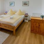 Ein Schlafzimmer mit Doppelbett, Holzmöbeln und Fenster.