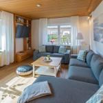 Wohnzimmer mit Sofa, Couchtisch und Fernseher an der Wand.