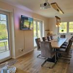 Esszimmer mit Langtisch, Stühlen und Fenstern zum Garten