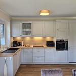 Küche mit hellen Schränken, Holzoberfläche und integriertem Backofen.