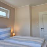 Schlafzimmer mit Bett, Fenster und Tür