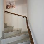 Treppe mit Holzgeländer und Wandbild an der Wand