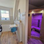 Badezimmer mit Sauna, Waschmaschine und Fenster.