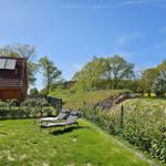 Haus mit Garten, Sonnenliegen und Blick auf Wald.