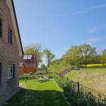 Haus mit Garten, Sonnenliegen und Blick auf Felder und Bäume.