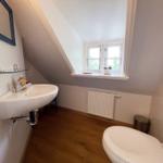 Badezimmer mit Waschbecken, Toilette und Fenster