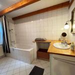 Badezimmer mit Badewanne, Waschbecken und Spiegel.