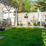 Hinterhof mit Grillplatz, Terrasse und grünem Rasenbereich.