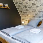 Schlafzimmer mit Bett, dekorativer Tapete und Bilderrahmen an der Wand.