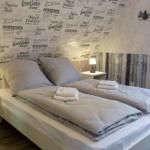 Schlafzimmer mit Doppelbett, zwei Nachttischen und dekorativer Wandtapete.