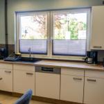 Küche mit Fenster, Spüle, Küchenspüle und Arbeitsfläche.