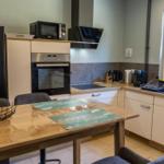 Küche mit Essbereich, Kühlschrank, Herd und Fenster.