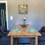 Essbereich mit Holztisch, vier Stühlen und Wandbild.