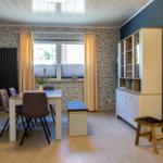 Esszimmer mit Tisch, Stühlen und Regal an der Wand.