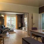 Wohn- und Essbereich mit Holzboden, Esszimmertisch und Blick auf Garten.