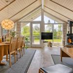 Großes Wohn- und Esszimmer mit Holzdecke, Kamin und Glastüren zur Terrasse.
