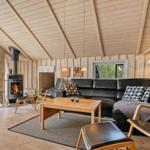 Wohnzimmer mit Holzwand, Sofa, Kamin und Fensterblick.