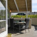 Terrasse mit Tisch und Stühlen unter Holzüberdachung
