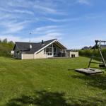 Haus mit großem Garten, Schaukel und Dartscheibe im Freien.