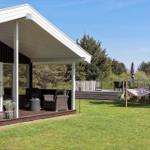 Haus mit Terrasse, Garten und Hängematten. Holzterrasse mit Sitzgelegenheiten.