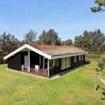 Moderne Holzhütte mit Terrasse und Garten. Hängem施cke im Vordergrund.
