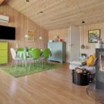 Wohnzimmer mit Kamin, Esstisch und TV. Holzwände und -boden.