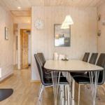 Esszimmer mit Tisch, Stühlen und Kaminofen. Holzwände und Boden.