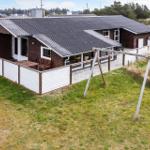 Holzhäuschen mit Terrasse und Garten. Holzveranda mit Sitzgelegenheit. Weiße Umzäunung und Schaukel.