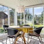 Glashalle mit Esstisch, Stühlen und Blick auf Garten