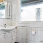 Badezimmer mit Waschbecken, Spiegelschrank und Fenster mit beschichtetem Glas.