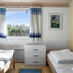 Zimmer mit zwei Betten, Fenster, Gardinen und Schrank.