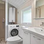 Badezimmer mit Dusche, Waschmaschine, WC und Waschbecken.