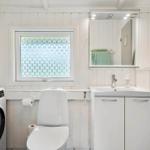 Badezimmer mit Waschmaschine, Toilette und Spiegel