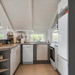 Küche mit Arbeitsplatte, Spüle, Kühlschrank und Waschmaschine.