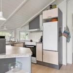 Küche mit Arbeitsplatz, Kühlschrank und Fenstern